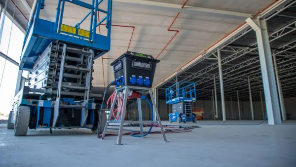 Load balancer oplaadstation van RECO in gebruik voor elektrische hoogwerkers op een bouwplaats