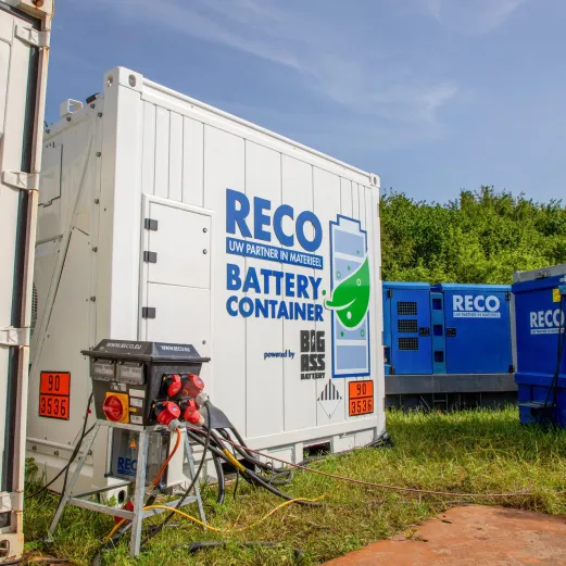 RECO 1 MWh batterijcontainer aangesloten op stroomvoorziening op een bouwlocatie.