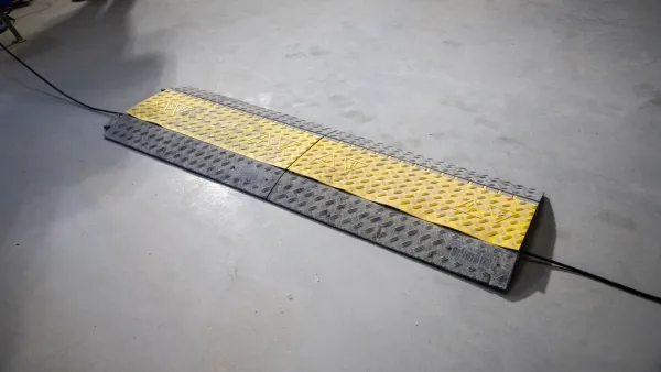 Kabelbrug over stroomkabel op de vloer voor veilige doorgang