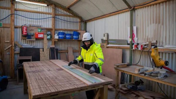 Medewerker aan het werk in een varianthal van 7,8 meter die is ingericht als tijdelijke werkplaats.