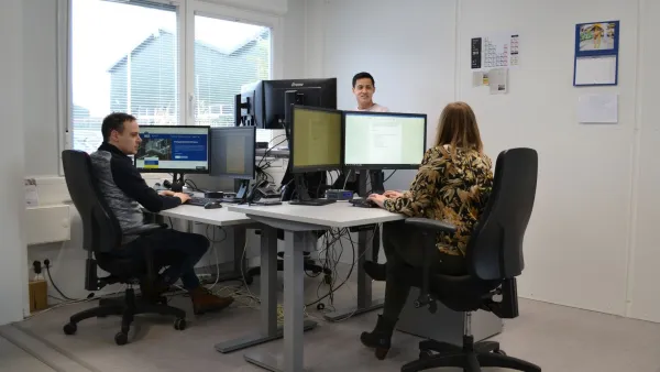 Medewerkers aan het werk in een ingerichte kantoorunit met bureaus en computerschermen