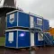 Gestapelde blauwe RECO bouwketen met buitentrap op locatie