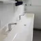 Wasruimte met wastafel en kranen in een sanitairunit.