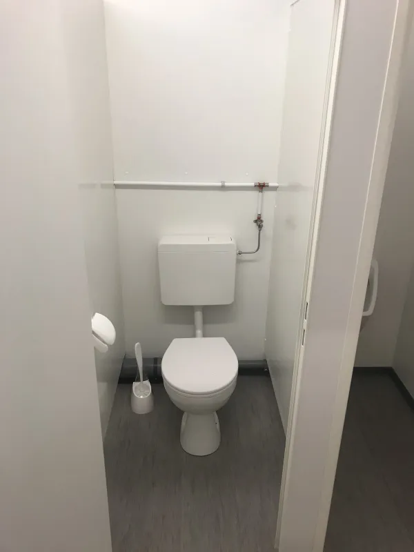 Toilet in een tijdelijke toiletunit met spoelreservoir.
