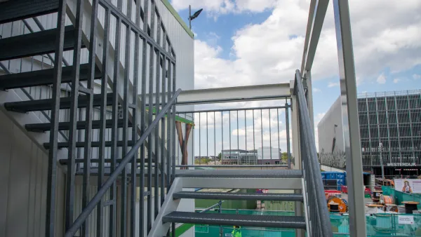 Trappenportaal met stalen trap en bordes voor veilige toegang tot gestapelde kantoorunits