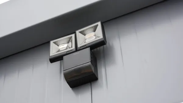 Buitenverlichting met bewegingssensor op kleine toiletunit.