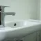 Wastafel met kraan in kleine toiletunit.