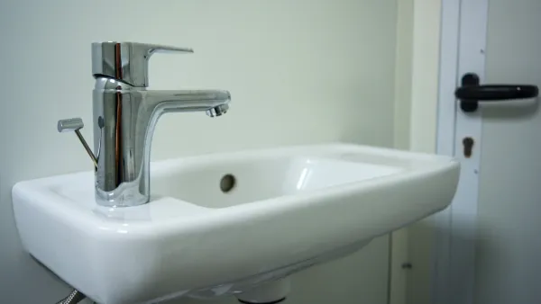 Wastafel met kraan in kleine toiletunit.