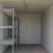 Binnenzijde van een 20 ft werkplaatscontainer met stellingen en verlichting