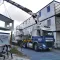 RECO vrachtwagen met kraan plaatst een bouwunit bij een modulair bouwkeetcomplex.