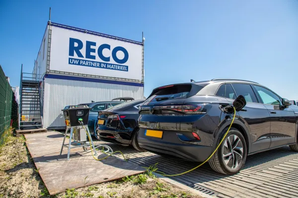 Elektrische auto’s worden opgeladen bij een RECO bouwkeet met laadvoorziening