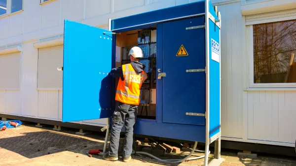 Monteur werkt aan een bouwmeterkast voor tijdelijke stroomvoorziening op de bouwplaats