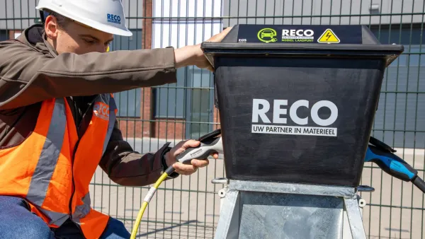RECO-medewerker sluit een laadkabel aan op een mobiele laadpaal