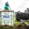 Vuilwaterinstallatie met opslagtanks en pomp naast een tijdelijke accommodatie
