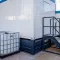 Meerdere watertanks van 1000 liter naast tijdelijke accommodatieunits